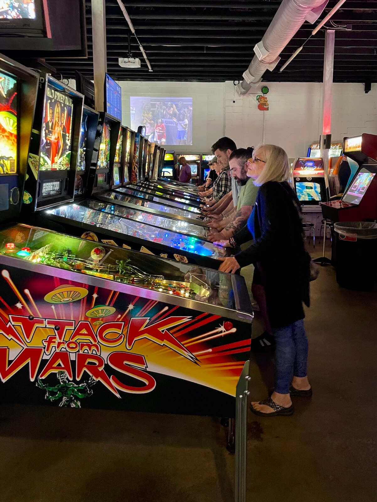 Pleople playing pinball games at Super Abari Game Bar in Optimist Park Charlotte