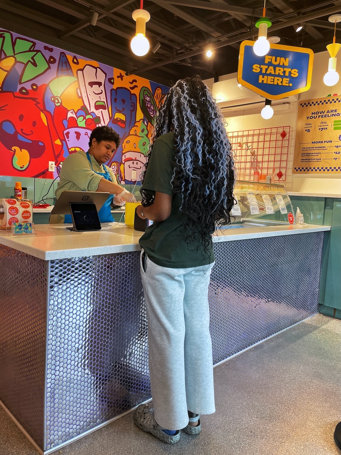 Woman ordering ice cream in a colorful Seemingly Overzealous Ice Cream in Camp North End Charlote