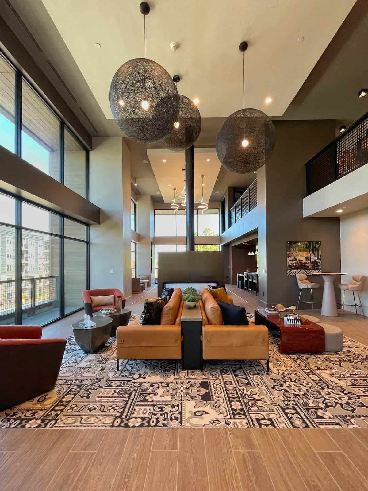 Lobby at Modera LoSo in Charlotte with high ceilings, contemporary lighting, and big leather chairs and sofas.