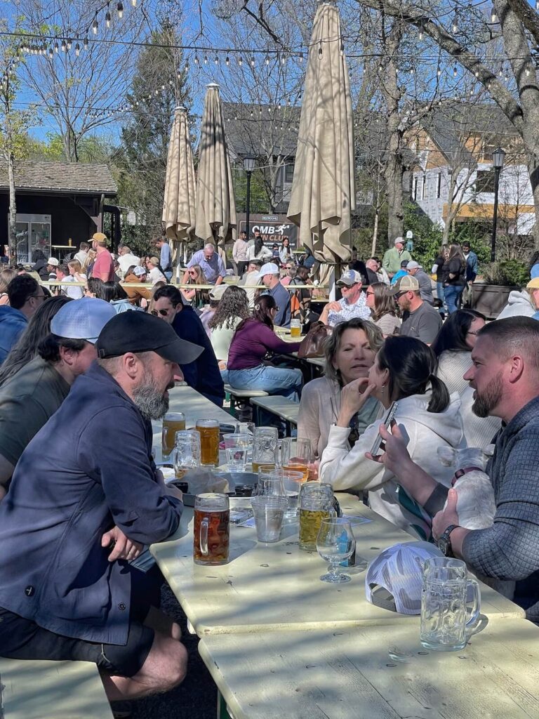 People drinking beer on at a picnic table at Olde Mecklenburg Brewery in LoSo Charlotte