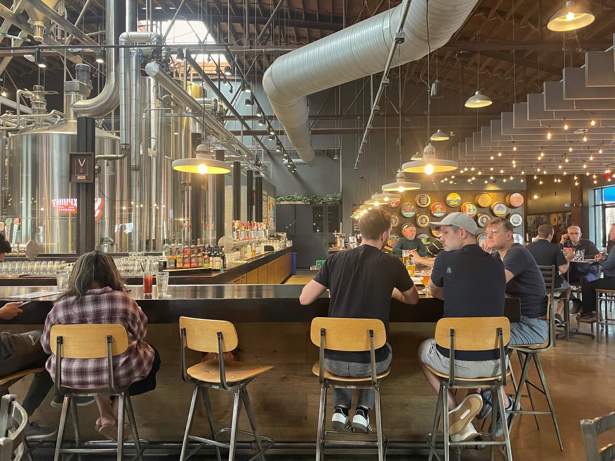 People sitting at bar inside of a brew hall in LoSo Charlotte