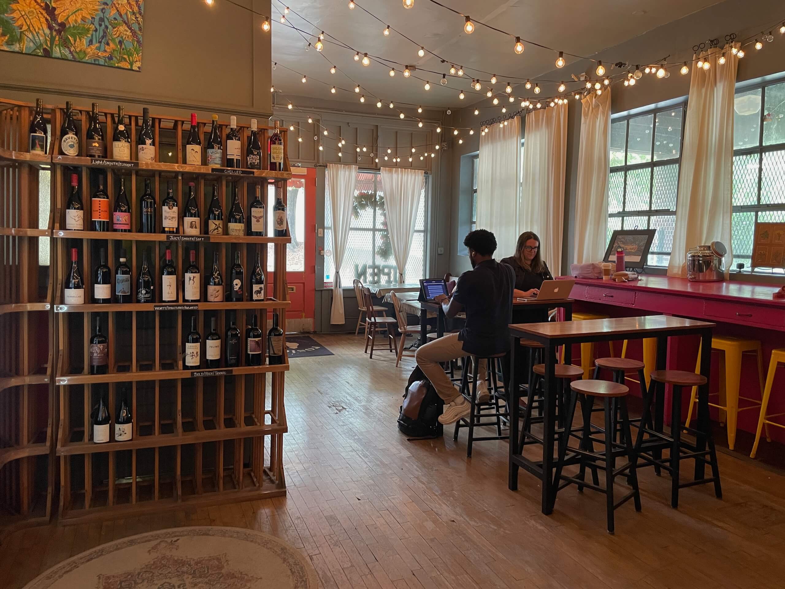 Two people working at a small table at Rosie's Coffee & Wine Bar in Optimist Park Charlotte