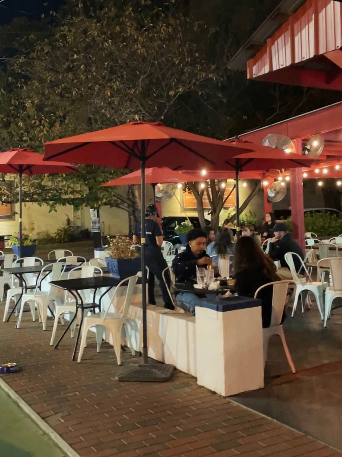 Patrons sit at tables outside Red Rooster restaurant in Plaza Midwood Charlotte at night