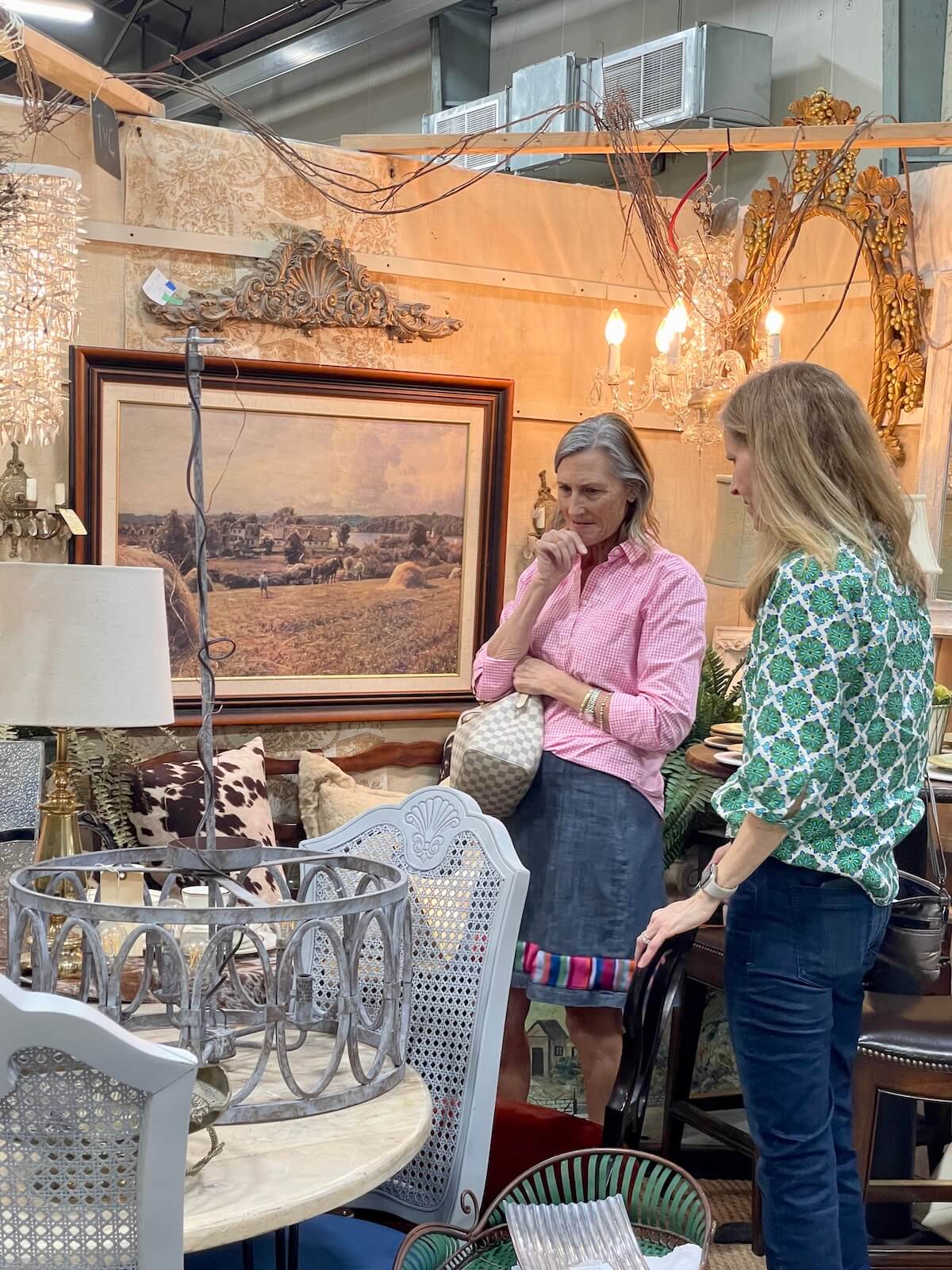 Two women looking at an antique lamp and table at Sleepy Poet Antique Shop in LoSo Charlotte