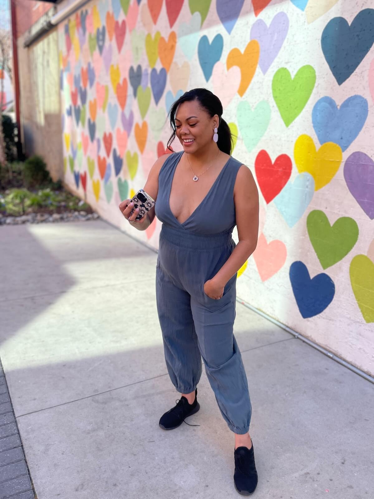 Woman taking a selfie in front of the heart wall mural in South End Charlotte