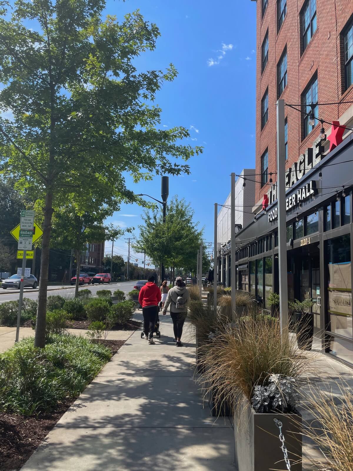 People walking on the sidewalk outside Atherton Mill in South End Charlotte
