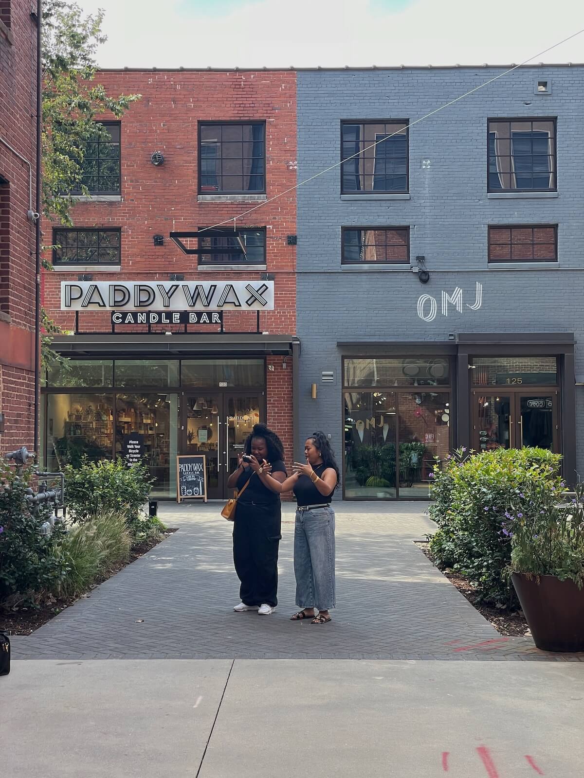 Two women standing and talking in front of shops in South End Charlotte