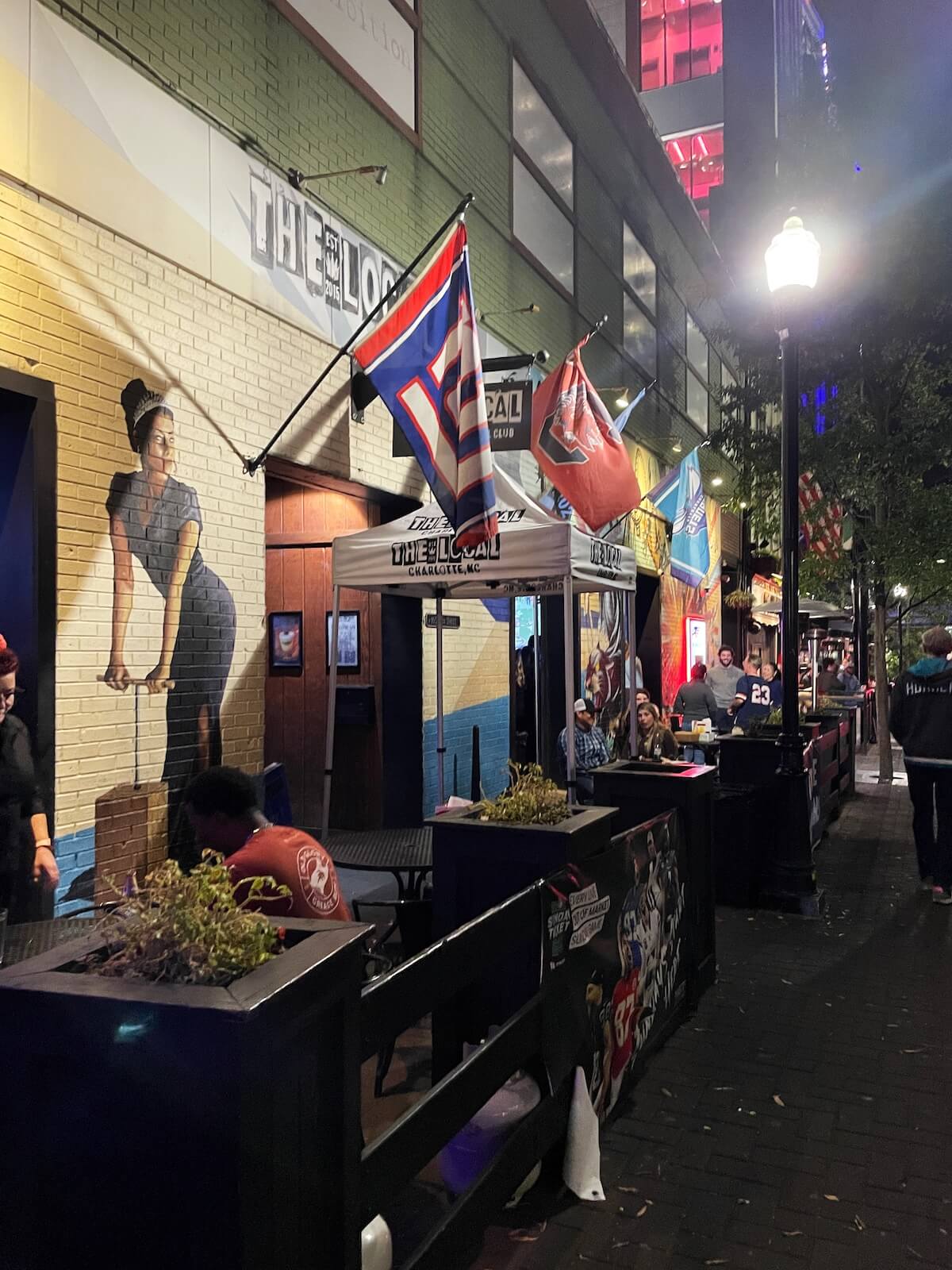 Patrons enjoying drinks on the patio outside The Local bar and restaurant in Uptown Charlotte