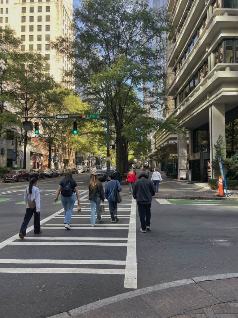 People crossing the street in Uptown Charlotte on a sunny day