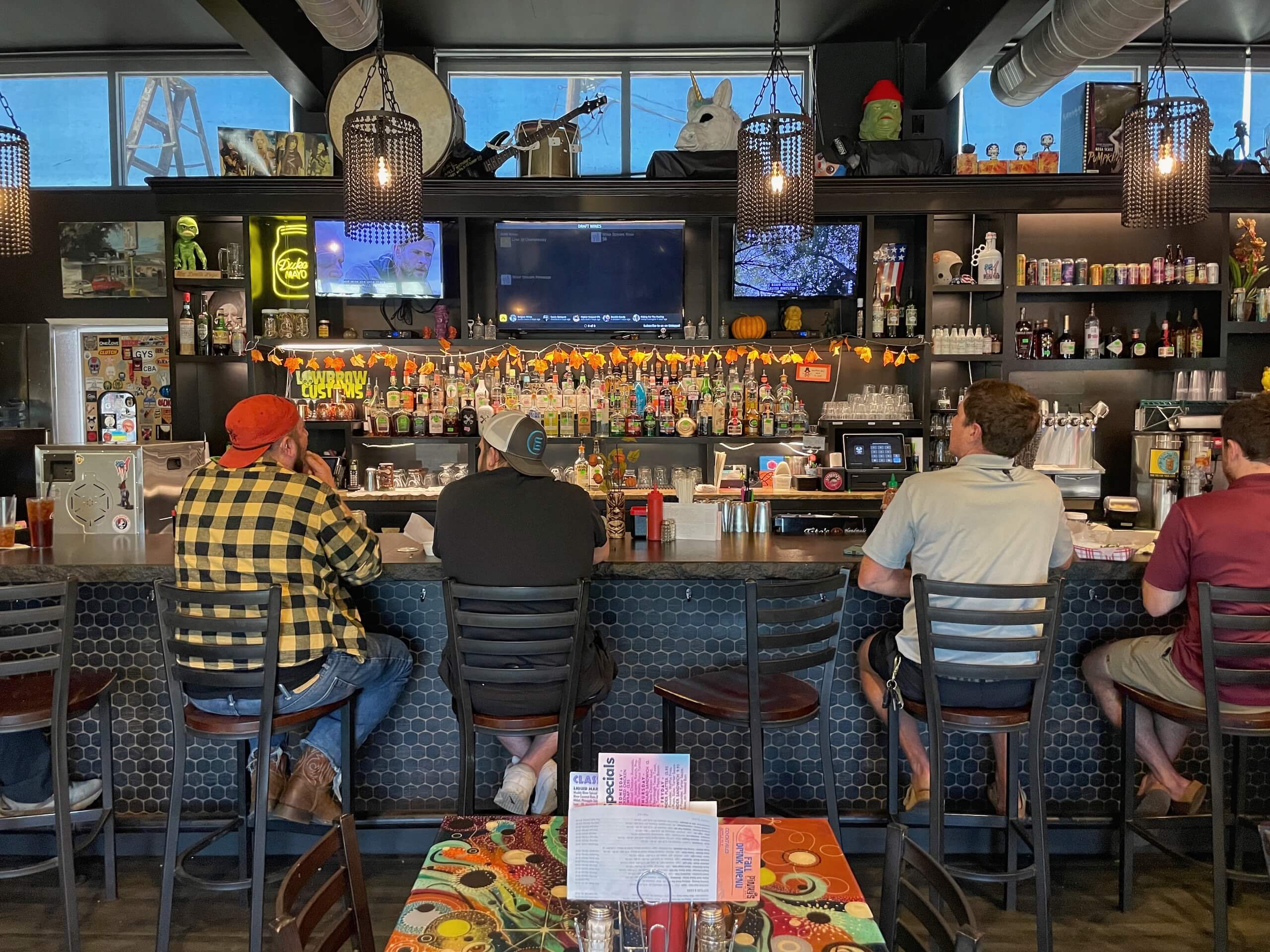 Men sitting at the bar watching TV at Pinky's Westside Grill in West End Charlotte
