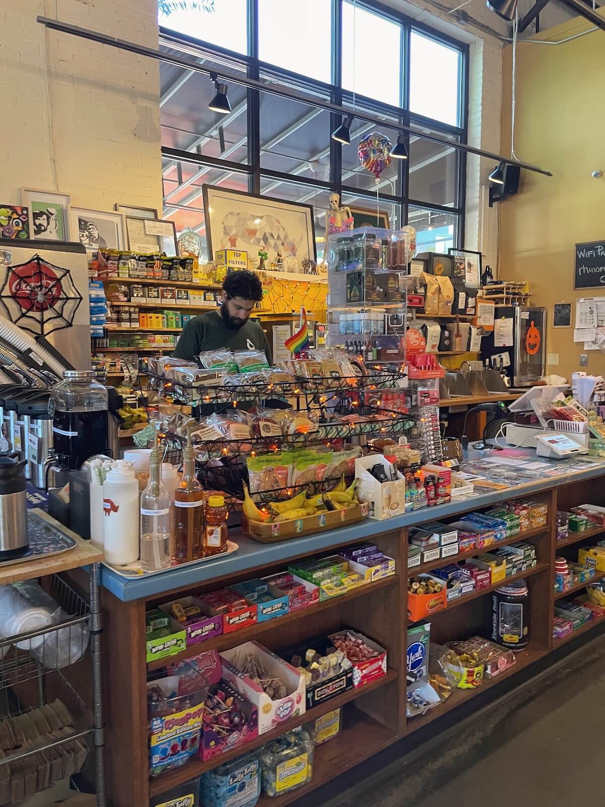 man working behind the counter register at Rino Market in West End Charlotte