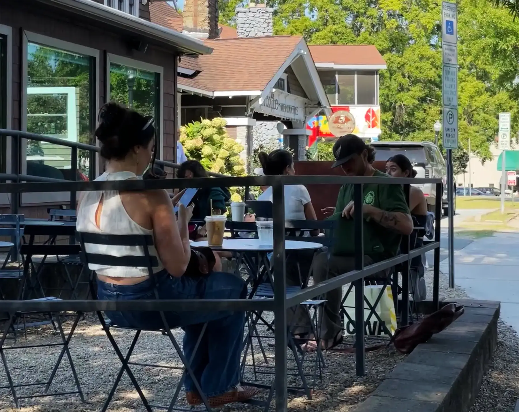 People sitting at tables at a sidewalk cafe in Plaza Midwood Charlotte